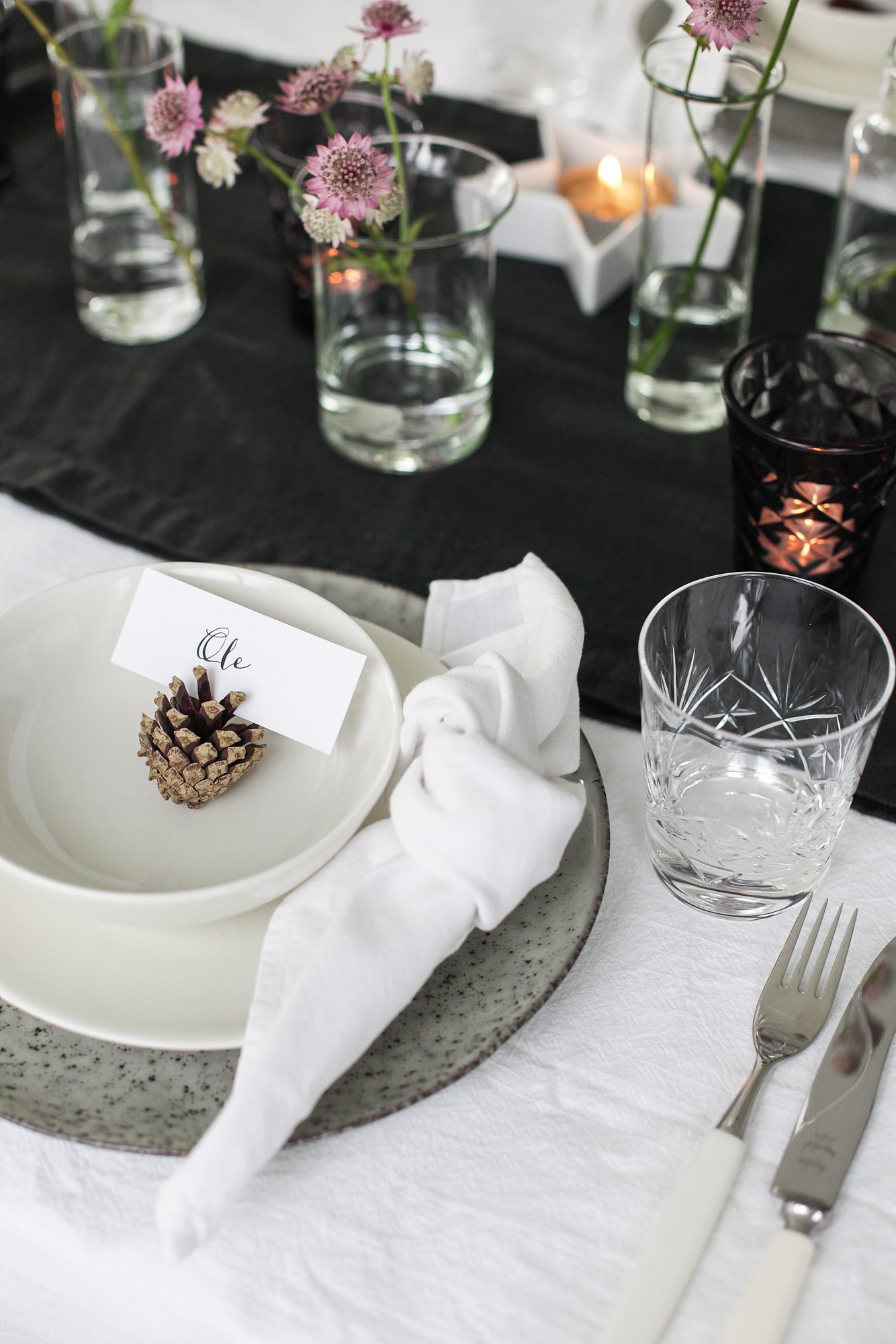 juledekket bord med kongle som bordkortholder
